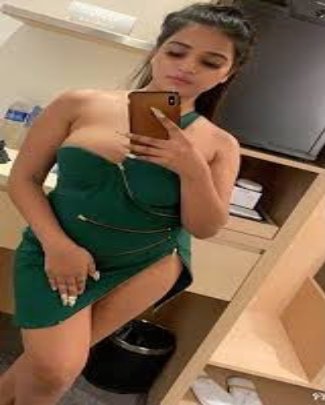 Name is Preeti age 24 years old in green dress taking selfie near glass